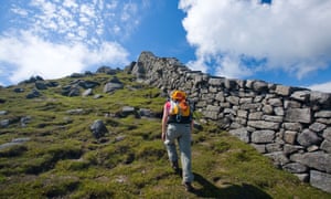 Walker beside the Mourne Wall on the ascent of Slieve Bearnagh Mourne Mountains