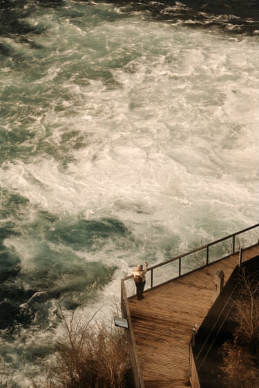A figure on a wooden walkway next to an unsettled ocean