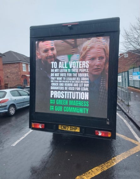 A van outside a polling station in the Gorton and Denton constituency. The back of the van shows a photograph of Zack Polanski and Hannah Spencer. The writing on the photograph says they want to ‘teach our children to use drugs including crack and heroin and let our daughters be used for legal prostitution’