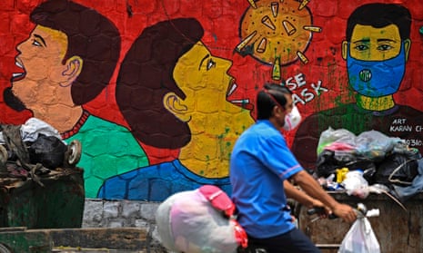 A cyclist passes a Covid awareness mural in New Delhi in July 2020