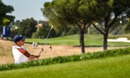 Rory McIlroy chips on to the green from the bunker on the sixth hole