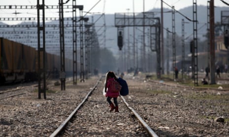 A child walks on a train track as migrants and refugees wait to cross the Greek-Macedonian borders
