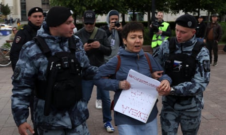 Russian national guard officers detain a woman during a protest at Pushkin Square on Sunday marking the birthday of imprisoned opposition politician Alexei Navalny.
