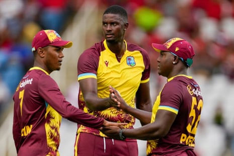 West Indies' Jason Holder, centre, celebrates with captain Rovman Powell and Akeal Hosein after the dismissal of England's captain Jos Buttler.