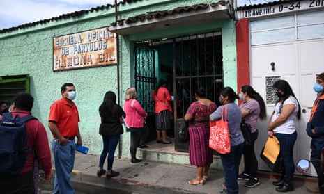 Parents wearing face masks queue to attend a ceremony marking the start of school at the Ramona Gil School in Chimaltenango, 60 km west of Guatemala City, on February 22, 2021.