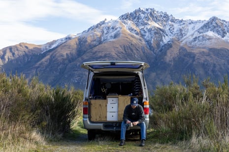 Merlin Traçable sits in the back of his van parked on the shores of Lake Wakatipu, New Zealand