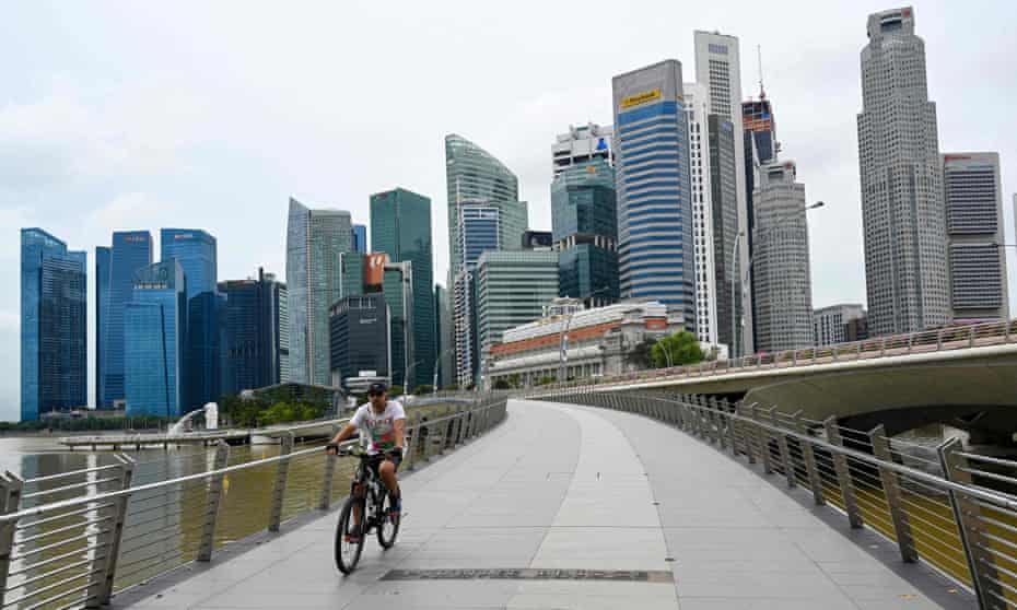 A man cycles along a bridge in Singapore on January 4, 2021, as the skyline is seen in the background. 