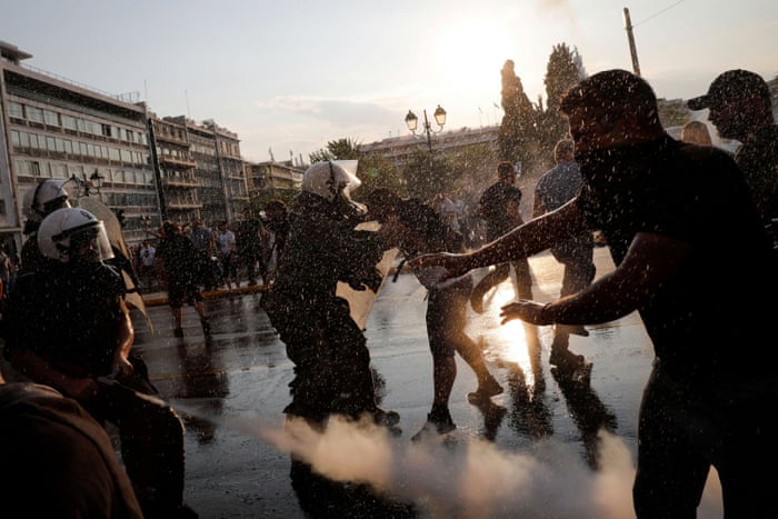 A police officer uses pepper spray against demonstrators during a protest against Covid vaccinations outside the parliament building in Athens, Greece.