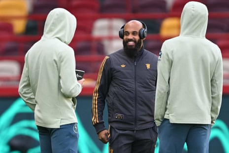 Bryan Mbeumo catches up with two behooded and unidentified former Brentford teammates upon his return to the Gtech Stadium.