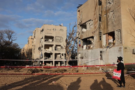 Man looks at missile damage in Arad, Israel