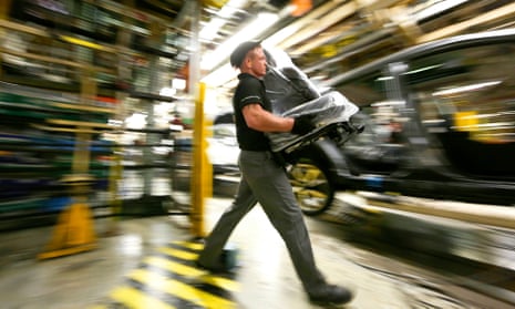 An employee prepares to fit a seat into a new Nissan Qashqai SUV automobile at the production line at Sunderland in 2014.