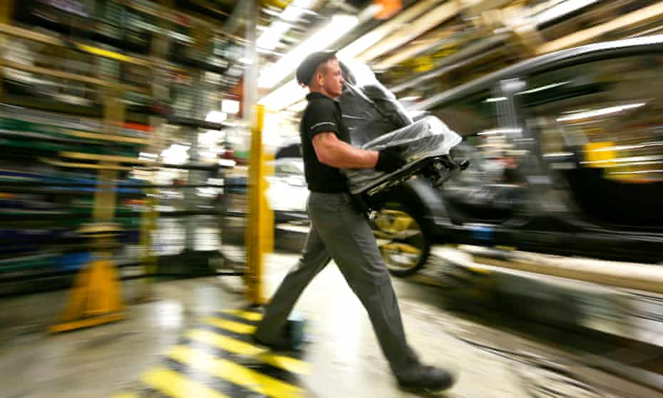 An employee prepares to fit a seat into a new Nissan Qashqai SUV automobile