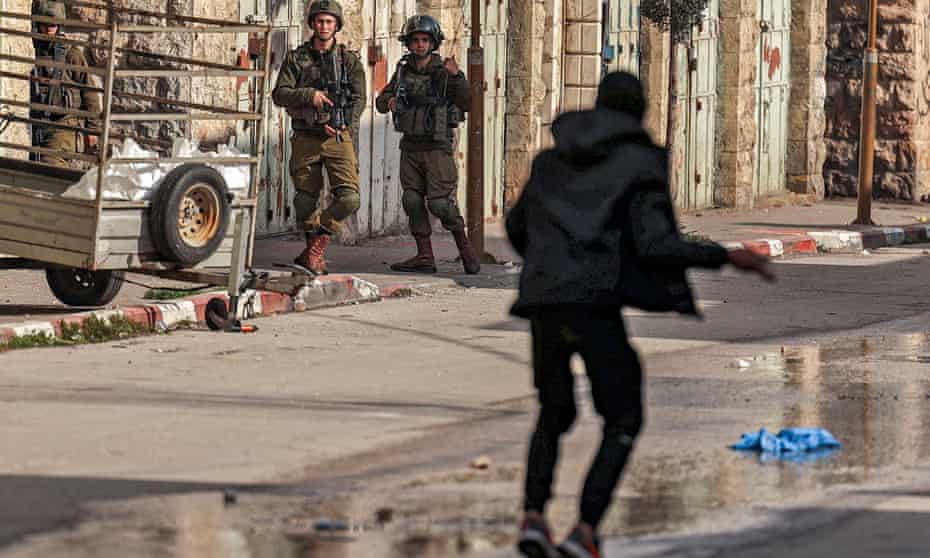 A Palestinian protester confronts Israeli soldiers during clashes in the centre of the city of Hebron in the occupied West Bank on 4 March.