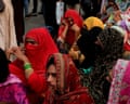 A group of transgender women wearing headscarves gather on a street