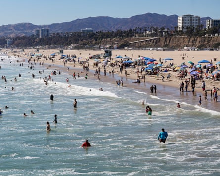 large crowds of people in water and on sand at beach