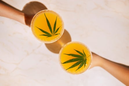 Two outstretched hands holding glasses with a cannabis leaf