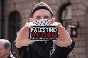 A man displays the Palestine Action logo on a phone