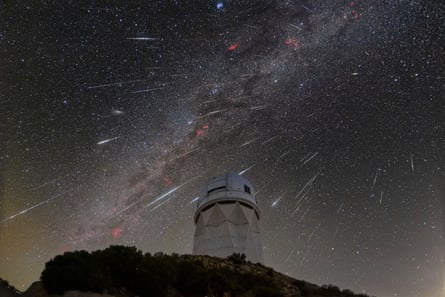 Meteors from the Geminid meteor shower streak across the sky above the Kitt Peak national observatory.