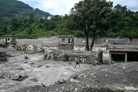 A man walks through the sludge in the aftermath of flash floods at Trishuli in Nepal’s Nuwakot district on 30 August.
