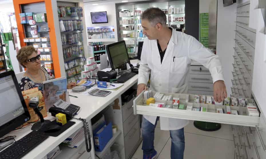 A Greek pharmacist serves a customer. Pharmacists have long been struggling with delays in reimbursements from the state, difficulties sourcing drugs and lack of funds.