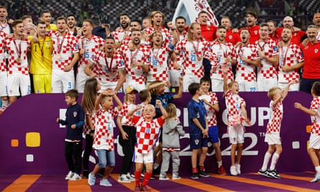 Croatia players, coaching staff and family members celebrate with their medals on stage as they finish in third place.