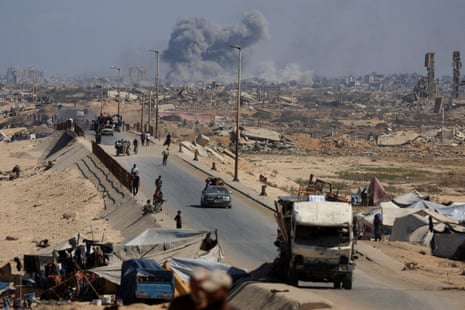 Smoke rises during an Israeli military operation as displaced Palestinians fleeing northern Gaza move southward after Israeli forces ordered residents of Gaza City to evacuate.