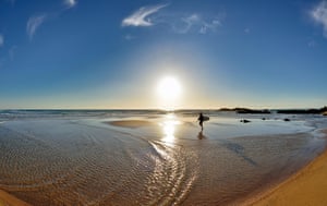 Surfista solitÃ¡ria caminhando na praia cÃªnica em Porto Covo, Portugal, Alentejo