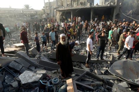 Palestinians look for survivors after an Israeli airstrike in Khan Younis refugee camp, located in the south of Gaza, inside the area that Israel has ordered residents of north Gaza to evacuate to.