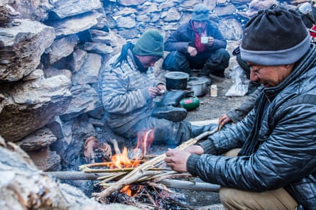 The porters take a break to cook food over an open fire.