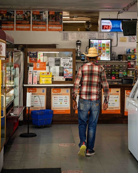 A man walks in a grocery store towards an empty money transfer desk