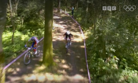 Pidcock takes the inside track while his opponent goes the other side of the trees.