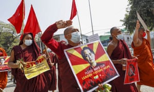 Buddhist monks and nuns display pictures of detained Myanmar leader Aung San Suu Kyi during a protest against the military coup in Mandalay, Myanmar on Tuesday.