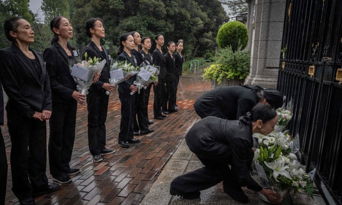 Members of a ballet company lay flowers outside the British embassy following the death of the Queen in Tokyo.