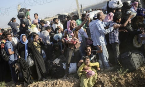 Syrians fleeing the war pass through border fences and trenches to enter Turkey illegally, near the Turkish border crossing at Akçakale in Şanlıurfa province on 14 June 2015.<br>
