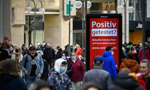 People walk on a pedestrian shopping street in the city centre of Cologne, Germany.