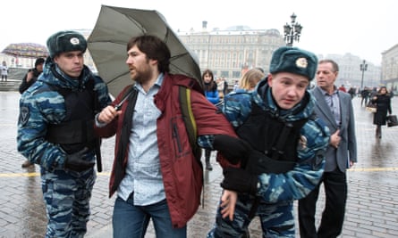 Russian riot police officers detain an activist demonstrating with an umbrella in support of Dozhd (TV Rain) in Moscow, 2014.