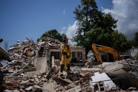 A Brazilian firefighters stand over the ruins of a building in La Guaira.