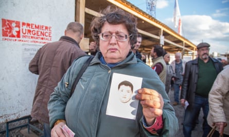 At the Mayorsk crossing point, Tatiana Chevchenko holds up a ­photograph of her son, Egor, who has 
disappeared.