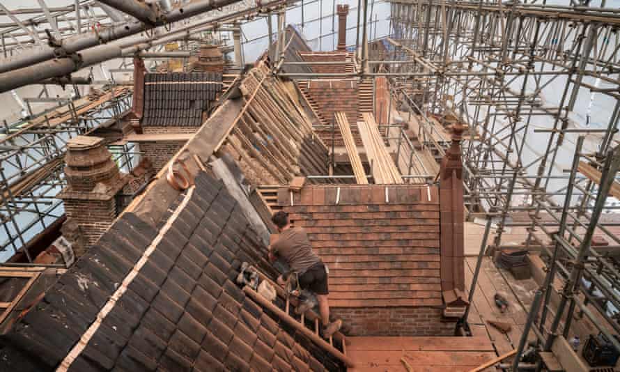 New tiles being fitted to the roof of the 15th-century moated manor house