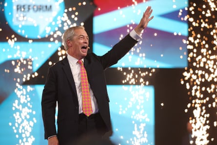 Nigel Farage waving at the audience amid a sparkling display of lights