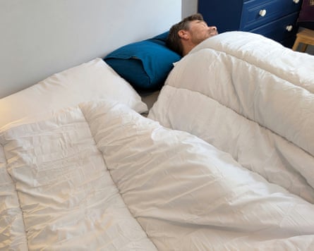 A man lies under the Silentnight Yours & Mine dual tog duvet.