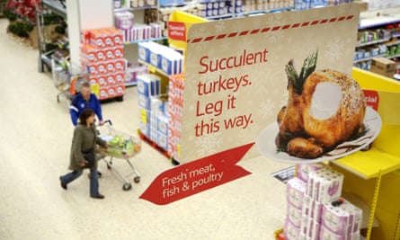 An advert for turkeys suspended from the ceiling at a Tesco. It says succulent turkeys, leg it this way