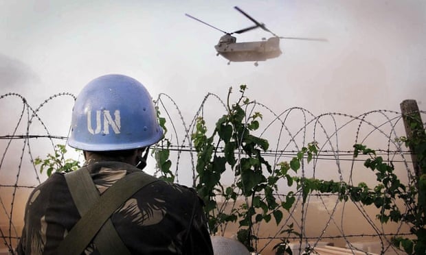 An Indian UN soldier watches an RAF Chinook helicopter