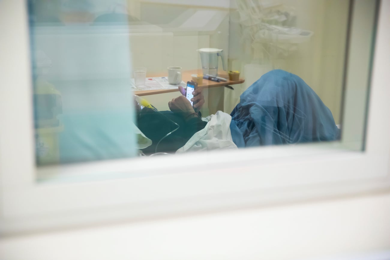 An unidentified patient communicates with loved ones via phone.