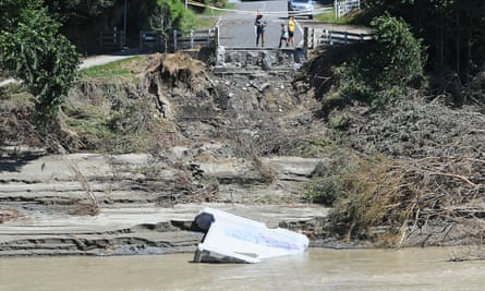 A road overlooking the riverbed has been sliced in half by the force of flood water.