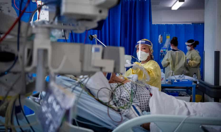 A nurse works on a patient in the ICU.