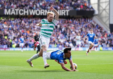 Bojan Miovski of Rangers falls to the ground under a challenge from Celtic’s Liam Scales
