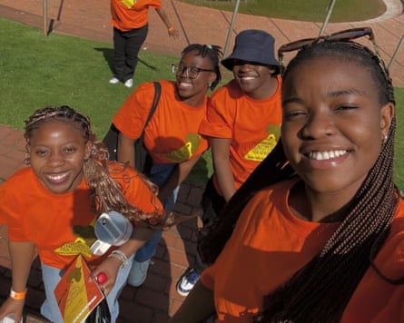 A group of smiling women in orange T-shirts