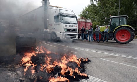 Farmers block access to vehicles as they protest on a bridge between France and Germany.
