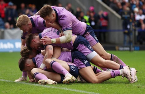 Scotland's Blair Kinghorn is mobbed by his teammates after scoring his fourth try.